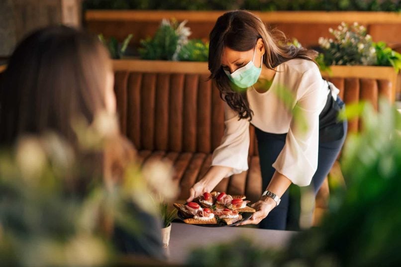 Texas Food Handler Serving Apetizers With A Face Mask