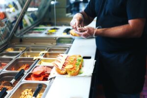 Food Handler Making Sandwhich With Gloves To Avoid Bare Hand Contact