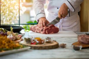 Texas Chef Cutting Beef On Cutting Board